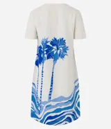 Vestido corto tipo t-shirt color crudo, con estampado de palmeras y olas en tonos azules.