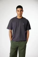 Remera de algodón de corte holgado y cuello redondo, con pequeño parche bordado en el pecho.