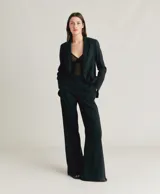 Pantalón palazzo negro de lino y algodón texturizado, con cintura alta, doble botón y bolsillos inclinados.