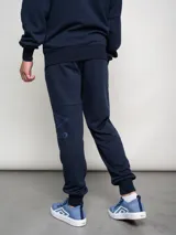 Pantalón de jogging azul marino de felpa con puños elásticos y logo de la marca estampado en la pierna izquierda.