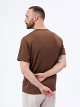 Remera de manga corta color marrón, con textura acanalada sutil y corte clásico.