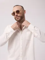 Camisa celeste de lino, de manga larga, con cuello abotonado y bolsillo en el pecho.