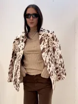 Blazer de corte clásico con solapas, bolsillos laterales y estampado de manchas de vaca en tonos marrón y beige.