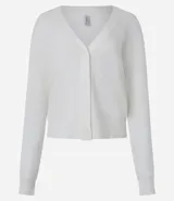 Cardigan de punto blanco, de manga larga y corte corto, con cuello en V y cierre frontal de botones. Presenta puños y bajo acanalados.