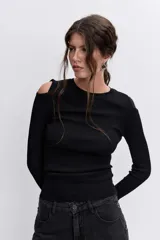 Blusa de punto acanalado color negro, con diseño de hombros descubiertos y manga larga.