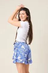 Short pollera con estampado de hojas color marrón y blanco, diseño cruzado, volados y lazo en la cintura.