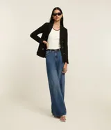 Musculosa de algodón rib, color blanco crudo, de corte regular y breteles anchos. Presenta un borde fino de color negro en el escote redondo y en las sisas.