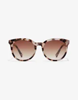 Lentes de sol Hawkers unisex, modelo Resort, con montura redonda de acetato color carey y lentes degradadas marrones.