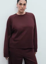 Buzo de cuello redondo y manga larga con diseño recto y holgado, confeccionado en tejido de viscosa con mezcla de poliamida y elastano.