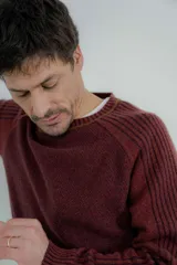 Sweater marrón de lana lambswool con cuello redondo y mangas largas. Presenta un diseño de punto texturizado en el cuerpo y mangas con detalle de punto acanalado en hombros y puños.