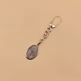 Llavero de plata 925 con dije ovalado que representa el símbolo de la medicina, con gancho mosquetón y cadena de eslabones gruesos.