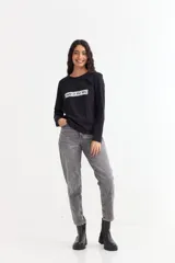 Remera de manga larga color beige con cuello redondo a la base. Presenta un estampado frontal con un dibujo de labios en color fucsia y la palabra 'BESITO' en color negro.