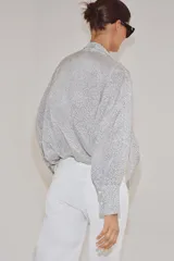 Camisa de viscosa con estampado de lunares pequeños, escote en pico con lazada frontal, manga larga y puños anchos.