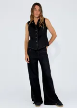 Chaleco color beige con escote en V, cierre frontal con botones y detalle de flecos en los bordes.