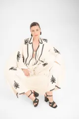 Sandalia de cuero negro con tiras cruzadas al frente, punta cuadrada y taco ancho. Cuenta con una pulsera ajustable al tobillo mediante hebilla metálica.