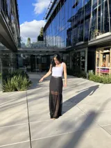 Blusa blanca con cierre frontal de cremallera plateada, corte ajustado y breteles anchos.