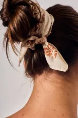 Bandana de poliéster color beige con estampado paisley en tonos marrones.