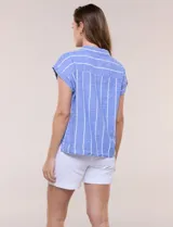 Camisa de lino azul a rayas blancas, sin mangas, con cuello camisero, escote en V y botones frontales.