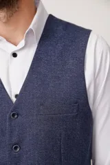 Chaleco azul con textura de espiga, cuello en V, cierre abotonado y bolsillos delanteros.