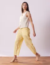 Pantalón capri amarillo de lino marca Zac & Rachel, con pretina elastizada, bolsillos delanteros y botones decorativos.