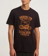 Remera negra de algodón con cuello redondo y mangas cortas. Estampa frontal con diseño de moto y texto "Brooklyn New York City 1976 Custom Motor Vintage Co.".