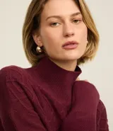 Suéter de manga larga confeccionado en tricot, con cuello alto y diseño de bordado de rombos en relieve. Presenta puños y ruedo acanalados.