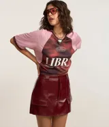 Short pollera de tiro medio confeccionado en poliuretano con acabado símil cuero. Presenta diseño de corte recto, cierre frontal con cremallera, trabillas para cinturón y dos bolsillos delanteros con solapa.