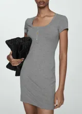 Vestido corto de tejido de punto acanalado en color gris, con cuello redondo, manga corta y cierre frontal con botones.
