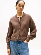 Cárdigan marrón de punto de algodón, con cuello redondo, cierre frontal con botones, mangas globo, puños y bajo de punto canalé, y dos bolsillos delanteros diagonales.