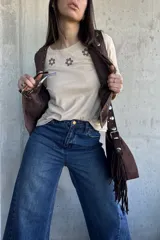 Remera beige de algodón con detalle de bordado floral en el pecho en tonos marrones y crudos.