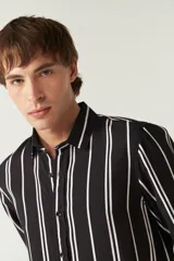 Camisa de mangas largas con estampado a rayas verticales en tonos verde oliva, blanco y azul. Corte regular y logo bordado en el pecho. Confeccionada en viscosa.