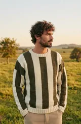 Sweater de punto en lana merino con diseño de rayas verticales en color chocolate y natural. Presenta cuello redondo, mangas largas y corte holgado.