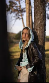 Tapado marrón de cuero con corte a la rodilla, mangas largas y aberturas laterales.