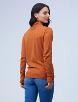 Polera gris de tejido fino con cuello alto y mangas largas con aplique de botones en los puños.