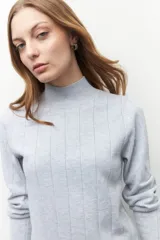 Polera de tejido de punto con cuello alto y diseño de rayas verticales sutiles. Presenta un ajuste al cuerpo y mangas largas.