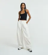 Blusa frente única de microfibra color beige, con escote cuadrado y breteles que se ajustan al cuello. Diseño sin mangas y espalda descubierta.