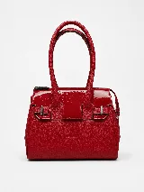 Cartera de mano estructurada de cuero vacuno rojo, con doble asa superior y detalles de charol en la parte superior. Cuenta con cierres metálicos y apliques decorativos laterales con hebillas.