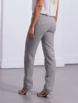 Pantalón sastrero de corte slim, color blanco, con pretina anatómica y panel interno modelador. Presenta bolsillos laterales tipo ojal, bolsillos traseros simulados y nervadura vertical marcada en el frente.