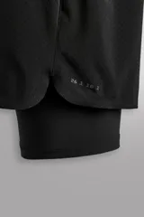 Short de running negro de tejido técnico perforado, ligero y elástico, con malla interior. Presenta cintura elástica ajustable con cordón interior, bolsillo trasero con cierre de seguridad y bajo con aberturas laterales.