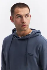 Canguro con capucha y cordones ajustables, de corte holgado y bolsillo frontal tipo canguro. Presenta un pequeño logo estampado en el pecho.