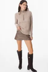 Sweater de punto gris con textura de ochos, cuello alto con cierre frontal parcial, manga larga y puños y ruedo acanalados.