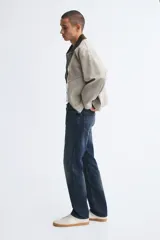 Pantalón jean de cinco bolsillos en denim de algodón con lavado azul oscuro, cintura clásica y corte de pierna recta.