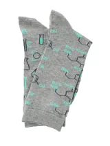 Medias de caña media color gris con estampado temático de química, incluyendo fórmulas moleculares y elementos de laboratorio en tonos azul y turquesa, con puntera y talón en color turquesa.
