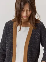 Saco abierto de punto con textura jaspeada en color gris oscuro, con bordes frontales en contraste color marrón. Presenta mangas largas y un corte recto.