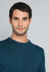 Sweater de algodón color verde petróleo, con cuello redondo y mangas largas.