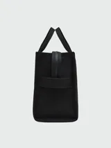 Bolso tote de lona color verde oliva con estampado frontal en blanco que dice 'THE TOTE BAG MARC JACOBS'. Cuenta con doble asa superior, correa de hombro ajustable y extraíble en color negro, y cierre superior con cremallera.
