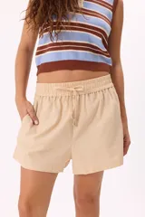 Short color beige de tela liviana, con cintura elastizada y lazo ajustable.