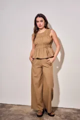 Blusa sin mangas de viscosa con estampado a cuadros vichy en tonos marrones y tostados, con doble fruncido elástico en el pecho y la cintura que genera un sutil vuelo inferior.