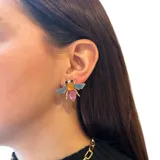 Aros pequeños con forma de mosca, hechos en base metálica dorada y resinas de colores.