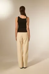 Top sin mangas de viscosa color negro, ajustado al cuerpo, con cuello redondo y frunces asimétricos en el hombro izquierdo.